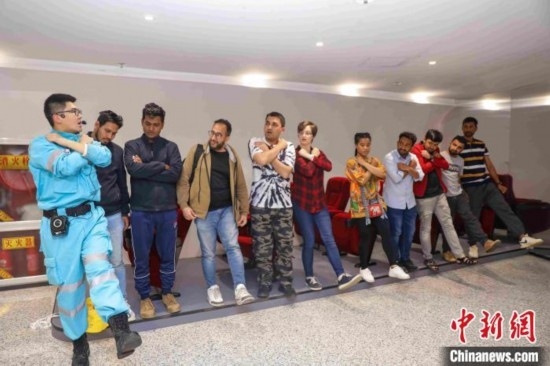 5月9日，工作人員指導(dǎo)留學(xué)生練習(xí)逃生技巧。張鷹 攝