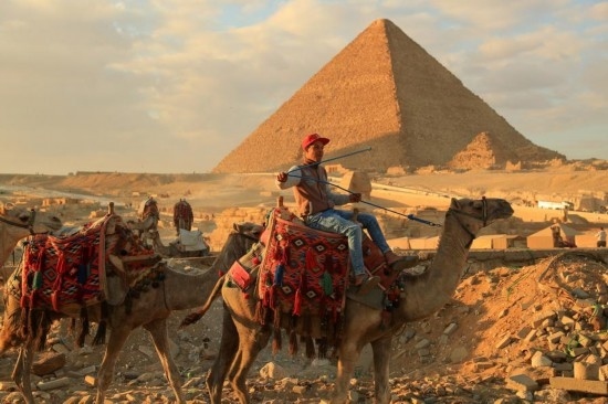 1月24日，商販騎駱駝離開埃及吉薩金字塔景區(qū)。新華社記者 隋先凱 攝