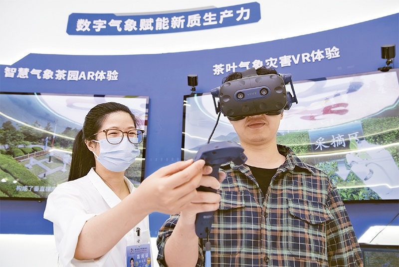 2024年5月23日，第七屆數(shù)字中國建設(shè)峰會現(xiàn)場體驗區(qū)在福州海峽國際會展中心向?qū)I(yè)觀眾開放。本次現(xiàn)場體驗區(qū)圍繞本屆峰會主題“釋放數(shù)據(jù)要素價值，發(fā)展新質(zhì)生產(chǎn)力”，設(shè)置“數(shù)字惠民”、“數(shù)字能力”、“數(shù)字基礎(chǔ)”、“數(shù)字生態(tài)”、“數(shù)字賦能”五大板塊。圖為一名觀眾（右）在數(shù)字氣象賦能新質(zhì)生產(chǎn)力展臺上進行體驗。 新華社記者 魏培全/攝