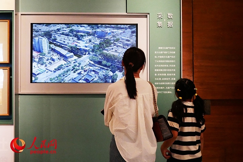 家長正在帶孩子參觀“輝煌中軸”專題展。人民網記者 韋衍行攝