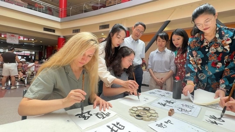 羅馬尼亞友人在活動現(xiàn)場學(xué)寫漢字。中國駐羅馬尼亞大使館領(lǐng)僑處供圖