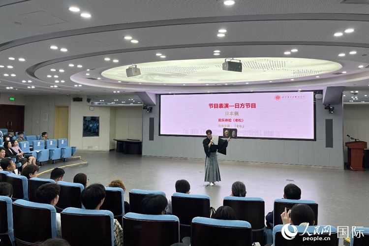 日本大學生介紹能樂知識。人民網(wǎng)記者 陳思攝