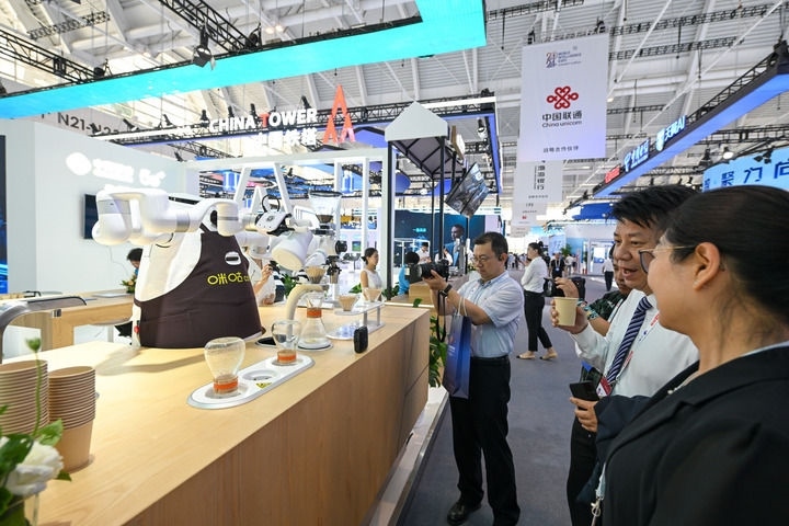 6月20日，與會(huì)者品嘗機(jī)器人沖調(diào)出的咖啡。新華社記者 孫凡越 攝