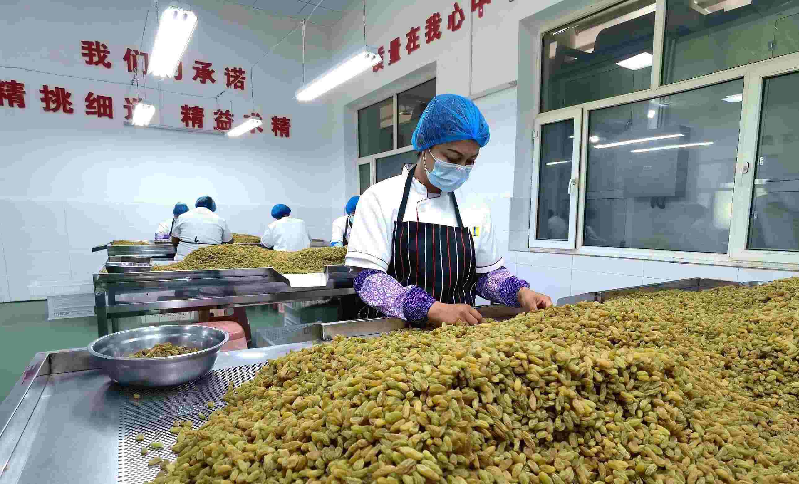 新疆吐魯番市高昌區(qū)亞爾鎮(zhèn)新城西門(mén)村，村民們?cè)诜謷咸迅伞? width=