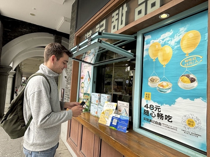 來自德國的留學(xué)生理查德在杭州西湖邊一家商鋪使用支付寶掃碼支付（2024年4月11日攝）。新華社發(fā)