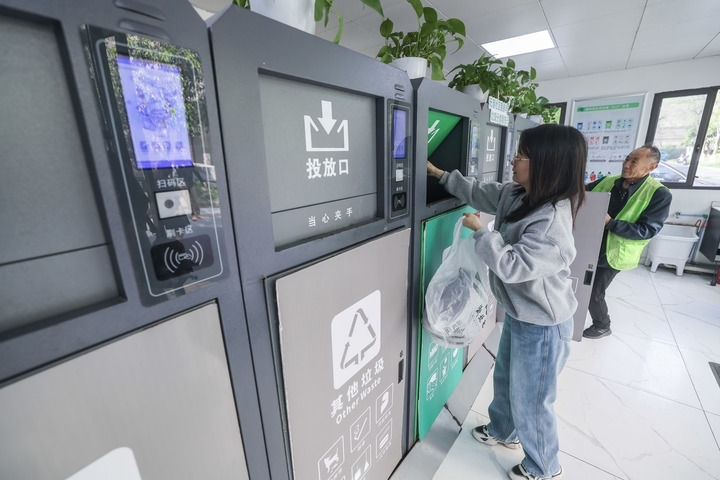 2024年4月10日，在浙江省湖州市吳興區(qū)飛英街道新華府小區(qū)內(nèi)，居民在垃圾分類智能系統(tǒng)的指導(dǎo)下進(jìn)行垃圾分類投放，居民的投放情況將實(shí)時(shí)匯總到智慧服務(wù)平臺，會(huì)有相應(yīng)的積分獎(jiǎng)勵(lì)。新華社記者 徐昱 攝
