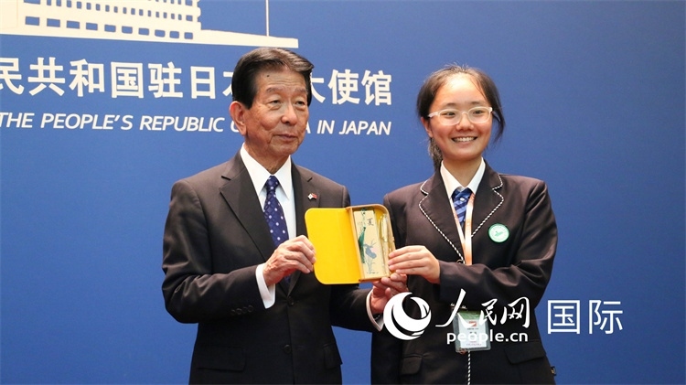 中國小大使向日本永旺1%俱樂部理事長森美樹贈送當?shù)靥厣Y品。人民網 許可攝