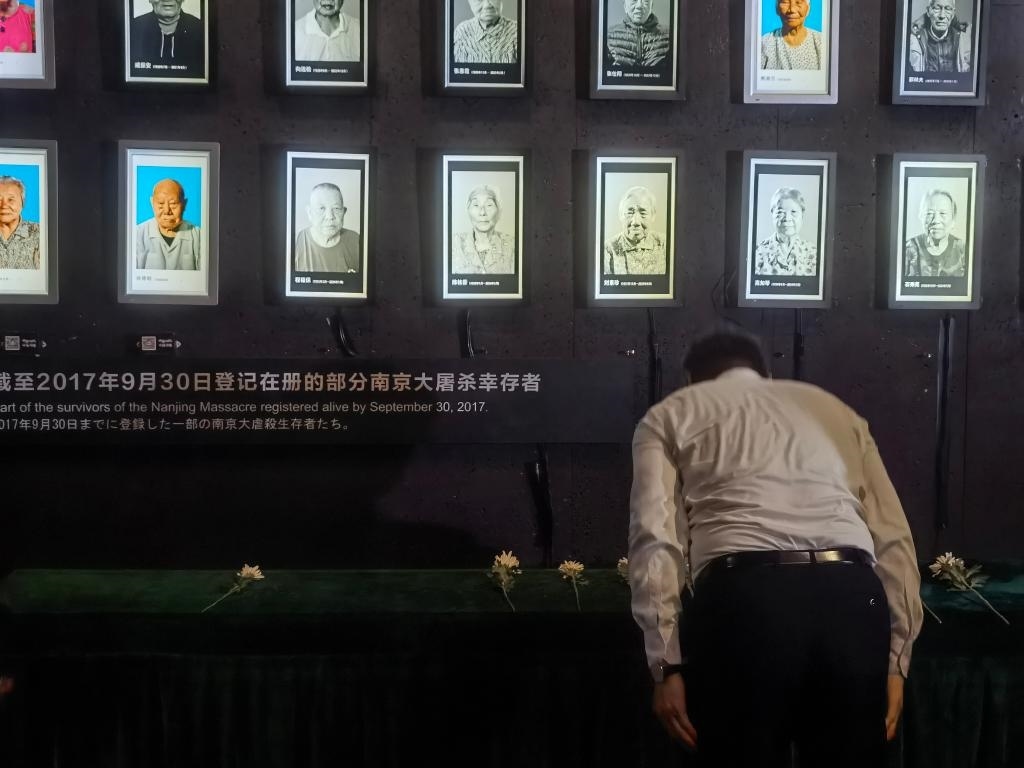 7月18日，人們向離世的南京大屠殺幸存者獻花、鞠躬。新華社記者邱冰清 攝