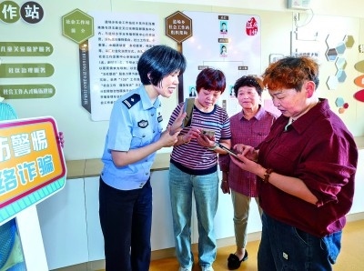 浙江湖州民警指導居民加入湖州“e企安”微信群，實時接收反詐信息。新華社發(fā)