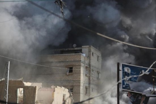 7月21日，在加沙地帶中部的努賽賴特難民營，遭以軍空襲的建筑冒出滾滾濃煙。新華社發(fā)（馬爾萬·達(dá)烏德攝）
