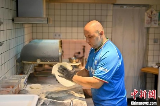 近日，韋榮耀在自家披薩小店內(nèi)忙活。俞靖 攝