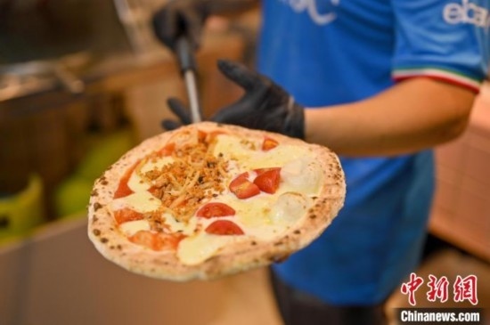 近日，韋榮耀展示他制作的“老友味”披薩。 俞靖 攝