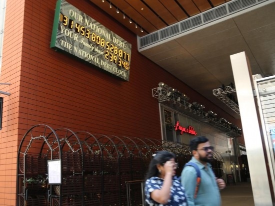 2023年5月29日，人們經(jīng)過美國(guó)紐約曼哈頓的“國(guó)債鐘”?！皣?guó)債鐘”是一個(gè)大型計(jì)數(shù)器，它實(shí)時(shí)更新美國(guó)的公共債務(wù)總額，并顯示出每個(gè)美國(guó)家庭所要負(fù)擔(dān)的數(shù)額。 新華社記者劉亞南攝