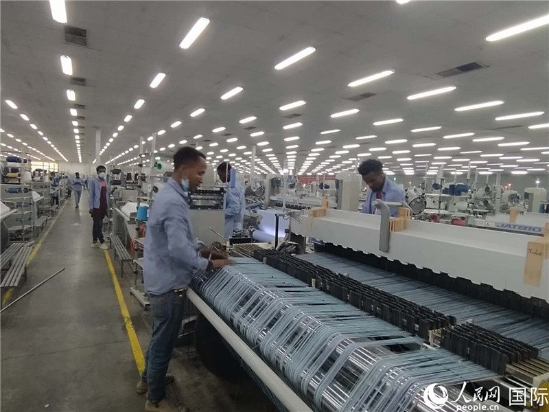 無錫金茂埃塞面料廠車間內(nèi)，當(dāng)?shù)毓と苏谝唤z不茍地作業(yè)。人民網(wǎng)記者 黃培昭攝