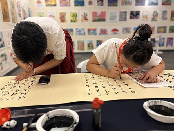 參加本次展覽的青少年在現(xiàn)場進(jìn)行書法創(chuàng)作。主辦方供圖