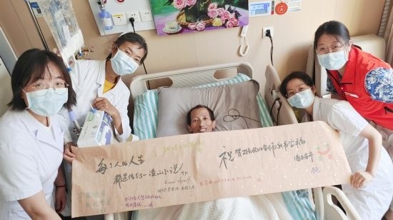 7月26日，海淀醫(yī)院安寧療護(hù)科醫(yī)護(hù)團(tuán)隊(duì)為朱銳送來(lái)一條寫滿祝福的橫幅。（受訪者供圖）