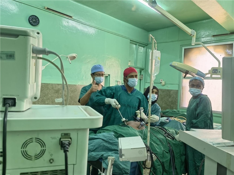 隊長蔣國慶（左一）關注當地醫(yī)生手術情況。中國援桑醫(yī)療隊供圖