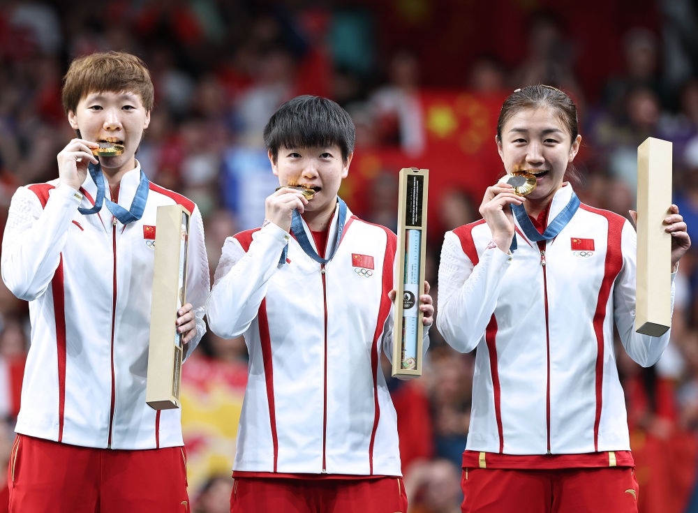 冠軍中國隊選手王曼昱、孫穎莎、陳夢（從左至右）在巴黎奧運會乒乓球女子團體頒獎儀式上（2024年8月10日攝）。新華社記者 王東震 攝