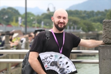 俄羅斯塔斯社執(zhí)行編輯葉夫根尼·扎多羅日內(nèi)在都江堰魚嘴拍照留念。（李佩藺 攝）