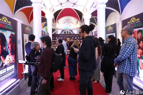 為期4天的第三屆中國－巴西電影展期間，來自中巴兩國的14部參展影片受到巴西電影愛好者和社會各界人士好評，圖為當(dāng)?shù)赜^眾在影展舉辦地巴西里約熱內(nèi)盧勞拉—阿爾維姆文化之家的迎賓廳欣賞參展電影海報。 人民網(wǎng)記者 陳一鳴攝