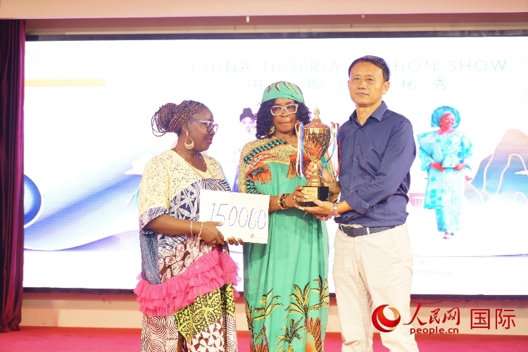 中國(guó)駐尼日利亞使館文化參贊兼中國(guó)文化中心主任李旭大（右）為最佳表現(xiàn)獎(jiǎng)?lì)C獎(jiǎng)（中）。人民網(wǎng)記者 姜宣攝