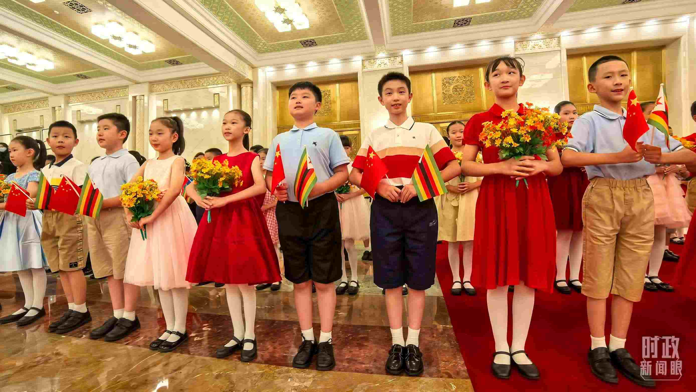 △現(xiàn)場歡迎津巴布韋總統(tǒng)訪華的青少年。（總臺央視記者鐘銳拍攝）