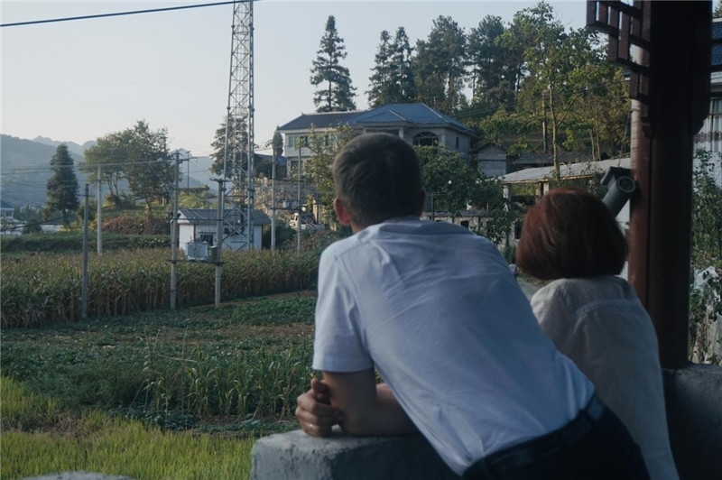 望得見山，看得見水，記得住鄉(xiāng)愁。每個人心中都有一個屬于自己的“花茂村”，在這方心田，走遍千山萬水，鄉(xiāng)音未改鬢毛衰。吉爾吉斯斯坦《比什凱克晚報(bào)》第一副總編輯妮娜·尼奇博洛娃與《中國與俄羅斯》雜志社社長奧列格·別列日內(nèi)赫攝在花茂村民居屋檐下并肩佇立，眺望山水，尋覓鄉(xiāng)愁。（李光裕攝）