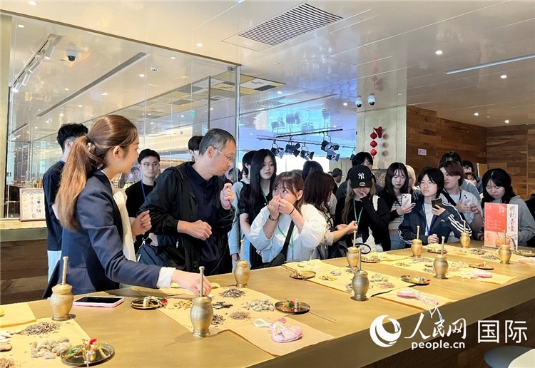 1. 日中友好協(xié)會(huì)青年代表團(tuán)一行學(xué)習(xí)中醫(yī)香囊制作工序。（人民網(wǎng)記者陳思 攝）