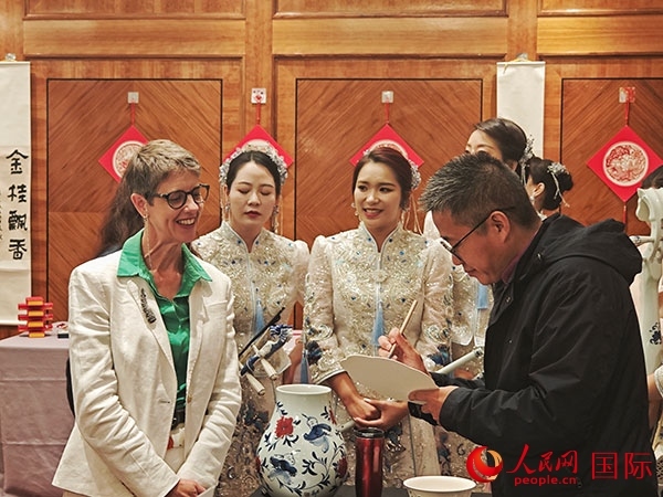 現(xiàn)場(chǎng)的非遺傳承人為英國(guó)觀眾展示畫技。人民網(wǎng)記者 邢雪攝