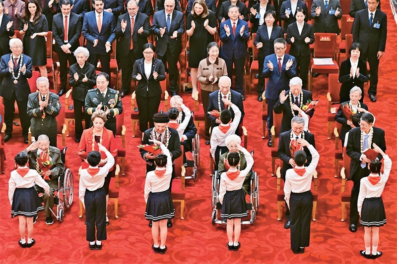 2024年9月29日，中華人民共和國(guó)國(guó)家勛章和國(guó)家榮譽(yù)稱(chēng)號(hào)頒授儀式在北京人民大會(huì)堂隆重舉行。圖為少先隊(duì)員向國(guó)家勛章和國(guó)家榮譽(yù)稱(chēng)號(hào)獲得者敬禮致意。 新華社記者 岳月偉/攝