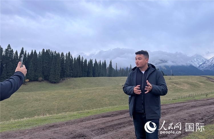 在庫爾德寧，吾買爾江被雪山美景震撼，即興錄制了短視頻作品。人民網(wǎng)記者曾書柔攝