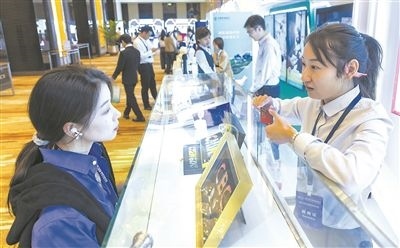 在北京麗澤商務(wù)區(qū)，工作人員（右一）介紹數(shù)字人民幣SIM卡硬錢包。新京報(bào)記者 陶冉攝