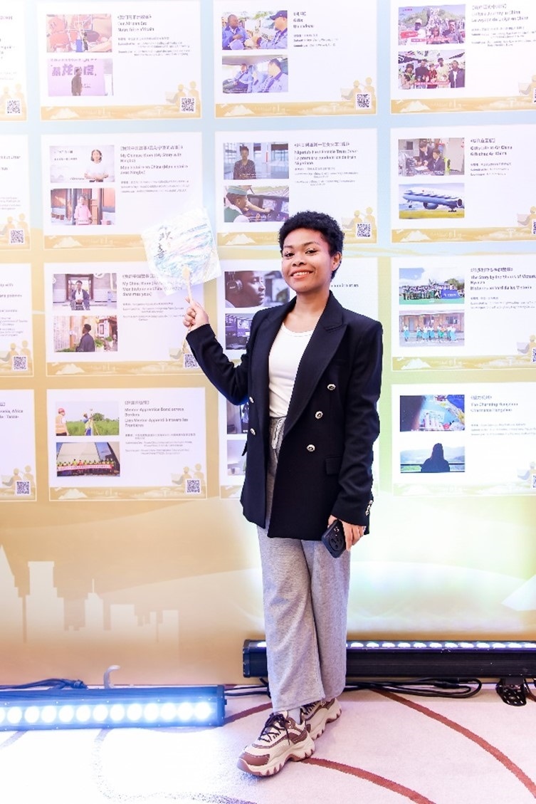 愈靈兒和她的作品合影。主辦方供圖