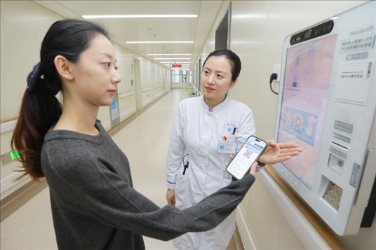 醫(yī)護(hù)人員引導(dǎo)患者在自助機(jī)前辦理自助入院手續(xù)。圖片來(lái)源：山東第一醫(yī)科大學(xué)第二附屬醫(yī)院