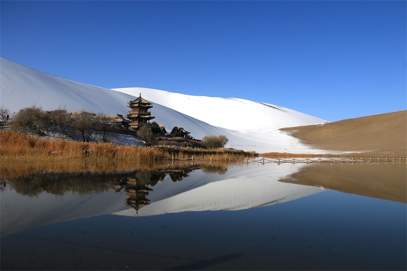 鳴沙山月牙泉景區(qū)雪景。敦煌市委宣傳部供圖，張曉亮攝