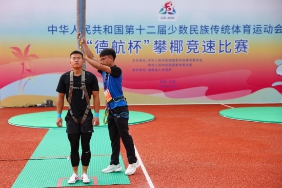 11月23日，工作人員為上海隊(duì)選手付樂樂（左）系安全繩。新華社記者 楊植森 攝