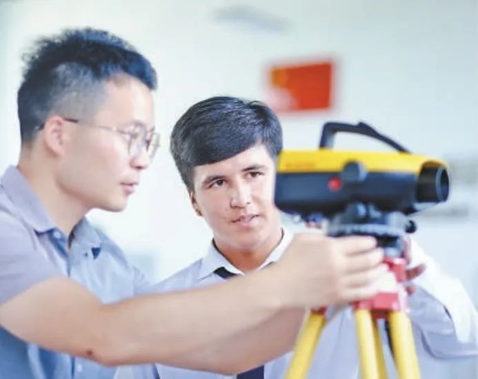 在塔吉克斯坦首都杜尚別的魯班工坊，來(lái)自天津城市建設(shè)管理職業(yè)技術(shù)學(xué)院的老師（左）為當(dāng)?shù)貙W(xué)生提供指導(dǎo)。新華社記者 鄭開(kāi)君 攝