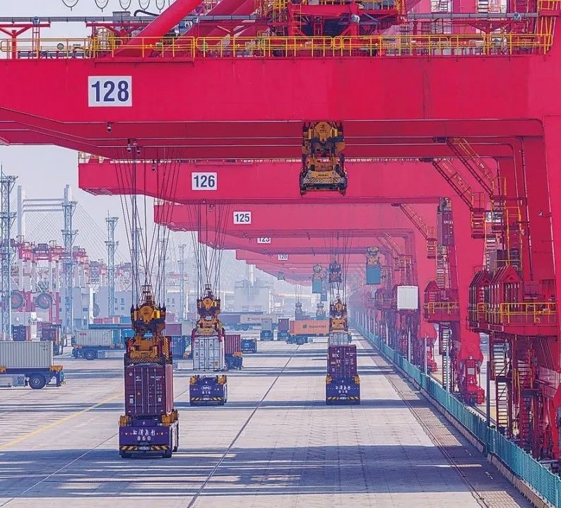 共建“一帶一路”國(guó)家在工作制度對(duì)接、技術(shù)標(biāo)準(zhǔn)協(xié)調(diào)、檢驗(yàn)結(jié)果互認(rèn)等方面強(qiáng)化合作、統(tǒng)一標(biāo)準(zhǔn)，貿(mào)易自由化便利化水平不斷提升。上海洋山港海關(guān)對(duì)接共建國(guó)家進(jìn)出口貨物相關(guān)標(biāo)準(zhǔn)，推動(dòng)通關(guān)一體化方式申報(bào)，提升通關(guān)效率。圖為無(wú)人駕駛的全自動(dòng)導(dǎo)引車(chē)在洋山港穿梭往來(lái)，搬運(yùn)集裝箱。王初 攝