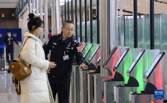 1月2日，大興機場邊檢站警察指導(dǎo)旅客使用自助出境設(shè)備。新華社記者 李欣 攝
