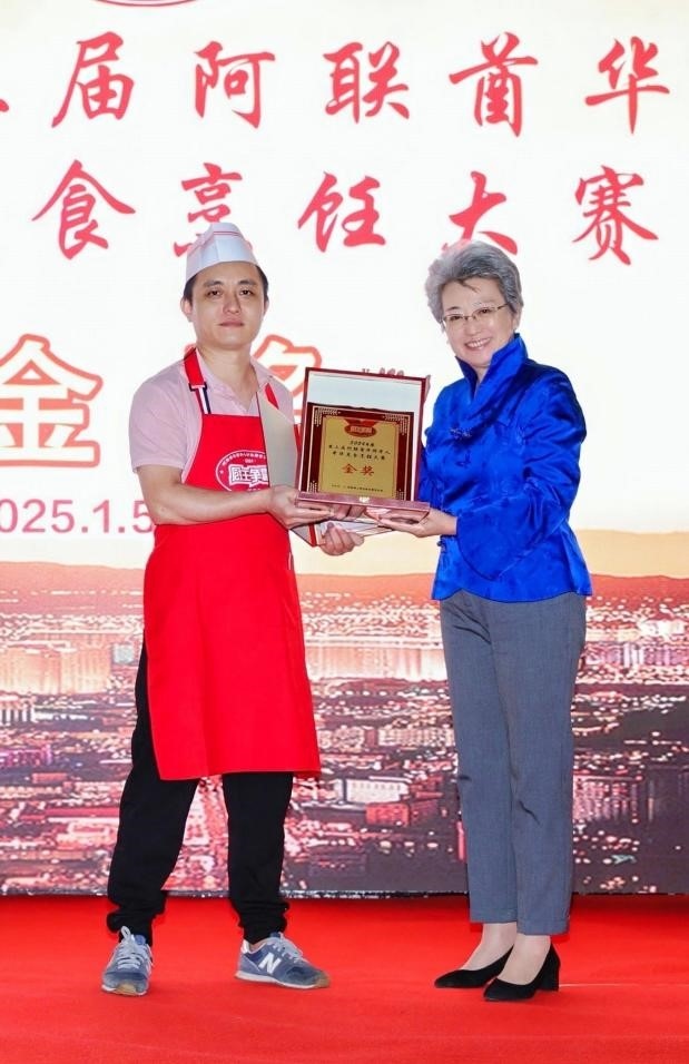 中國駐迪拜總領(lǐng)事歐渤芊（右）為金獎獲得者頒獎。主辦方供圖