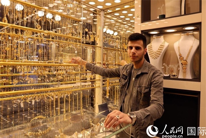 一名銷售員展示黃金飾品。人民網(wǎng) 伊納斯·易卜拉欣攝