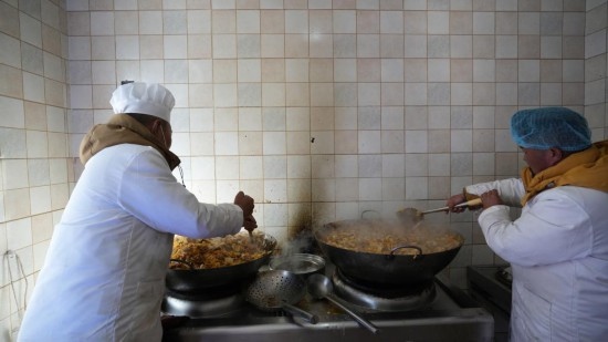 1月14日，服務(wù)隊的兩名廚師正在為村民們做午飯。新華社記者 邱星翔 攝