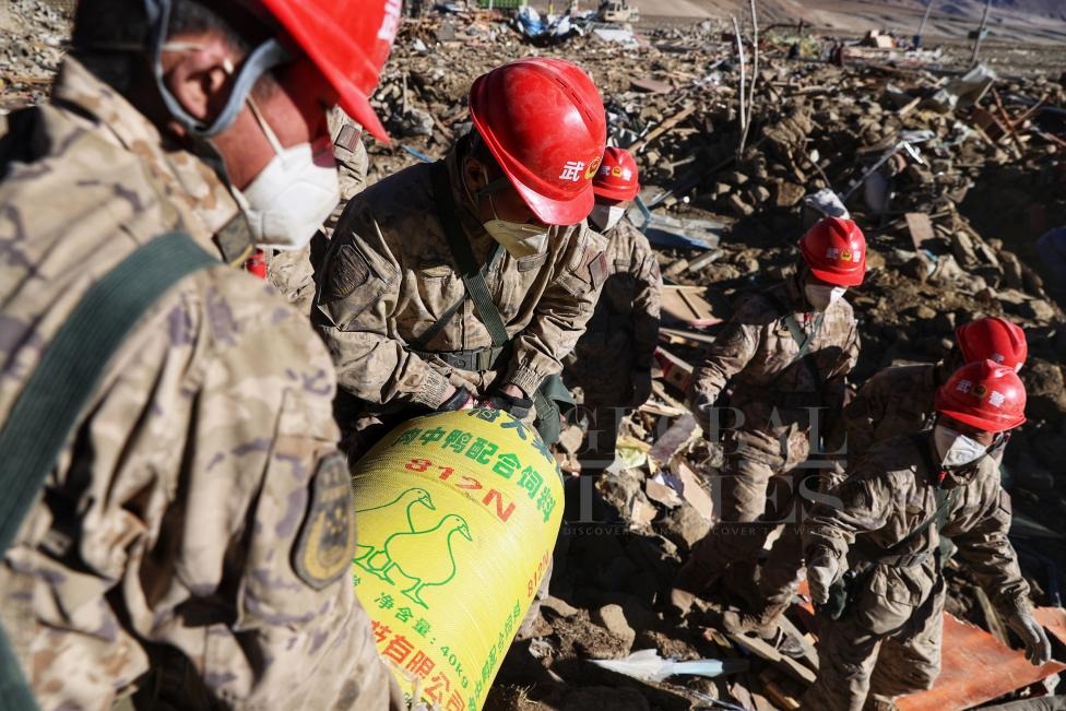 1月10日，定日縣長所鄉(xiāng)古榮村，武警官兵幫助受災群眾整理廢墟，搶救被掩埋的物資。環(huán)球時報記者崔萌攝