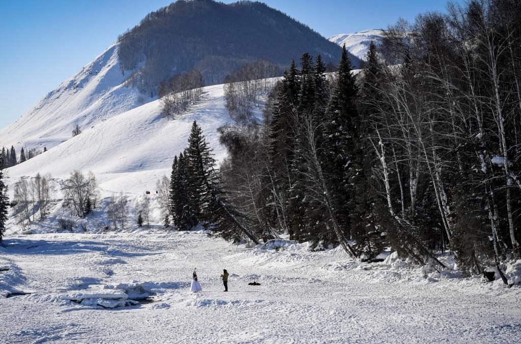 2024年2月5日，兩名游客在新疆阿勒泰地區(qū)布爾津縣禾木村拍照。新華社記者 馬鍇 攝