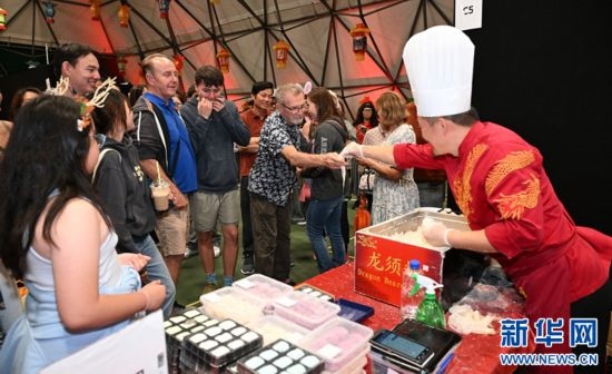 圖為游客在燈節(jié)現(xiàn)場購買小吃。（圖片由奧克蘭中國文化中心提供）