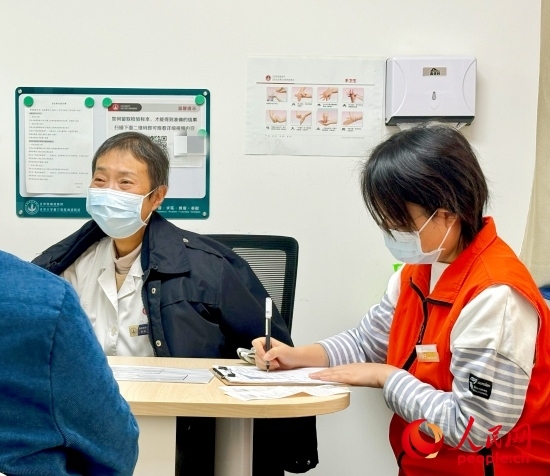 秦苑（中）接診患者。人民網(wǎng)記者 金慧慧攝