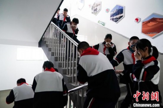  圖為學(xué)生們進(jìn)行應(yīng)急疏散演練。中新社記者 趙宇航 攝