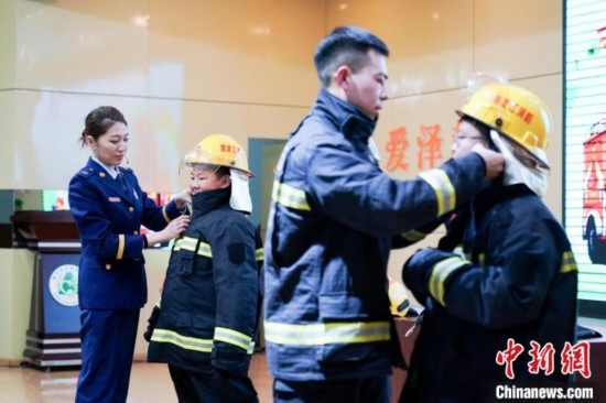 圖為學(xué)生們現(xiàn)場(chǎng)穿戴消防頭盔和戰(zhàn)斗服。中新社記者 趙宇航 攝