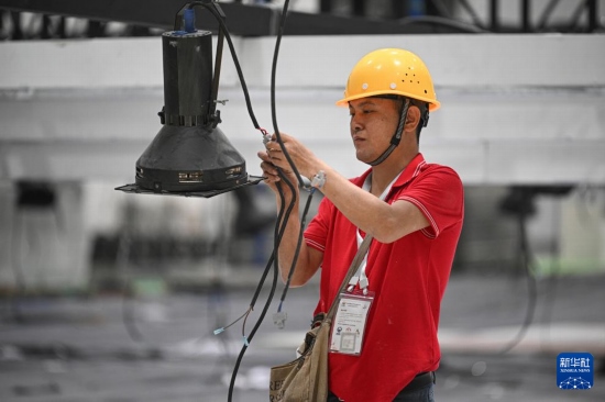 4月4日，工作人員在海南國(guó)際會(huì)展中心內(nèi)布設(shè)燈光。