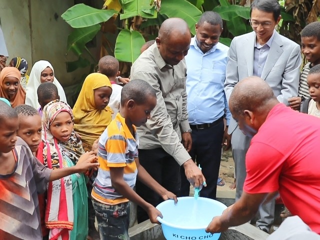 在日前舉行的安全供水工程揭牌儀式上，當地小朋友在供水點接水。 施亮攝